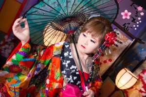 鮮やかな刺繍の入った打掛を着て和傘に手を添える現代風花魁