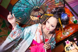 鮮やかな水色の打掛を着て和傘を持つ現代風花魁