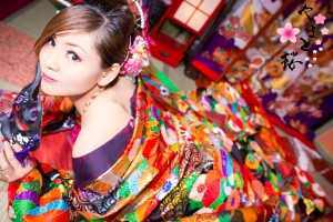 豪華な刺繍の入った色鮮やかな打掛を着て猫面を持つ現代風花魁