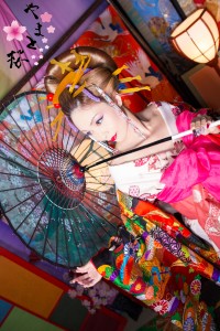 色とりどりの刺繍の入った打掛を着て和傘に手を添える本格古典風花魁