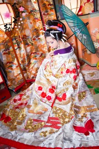 白地に赤・金の刺繍をあしらった打掛を着て和傘を持つ白かんざしの本格古典風花魁