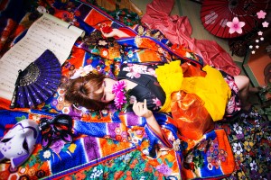 色とりどりの刺繍の入った豪華な打掛を着て花を持つ寝姿の現代風花魁