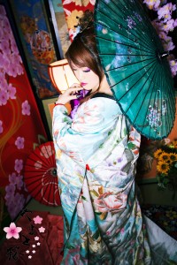 綺麗な水色の打掛を着て和傘を持つ立ち姿の現代風花魁