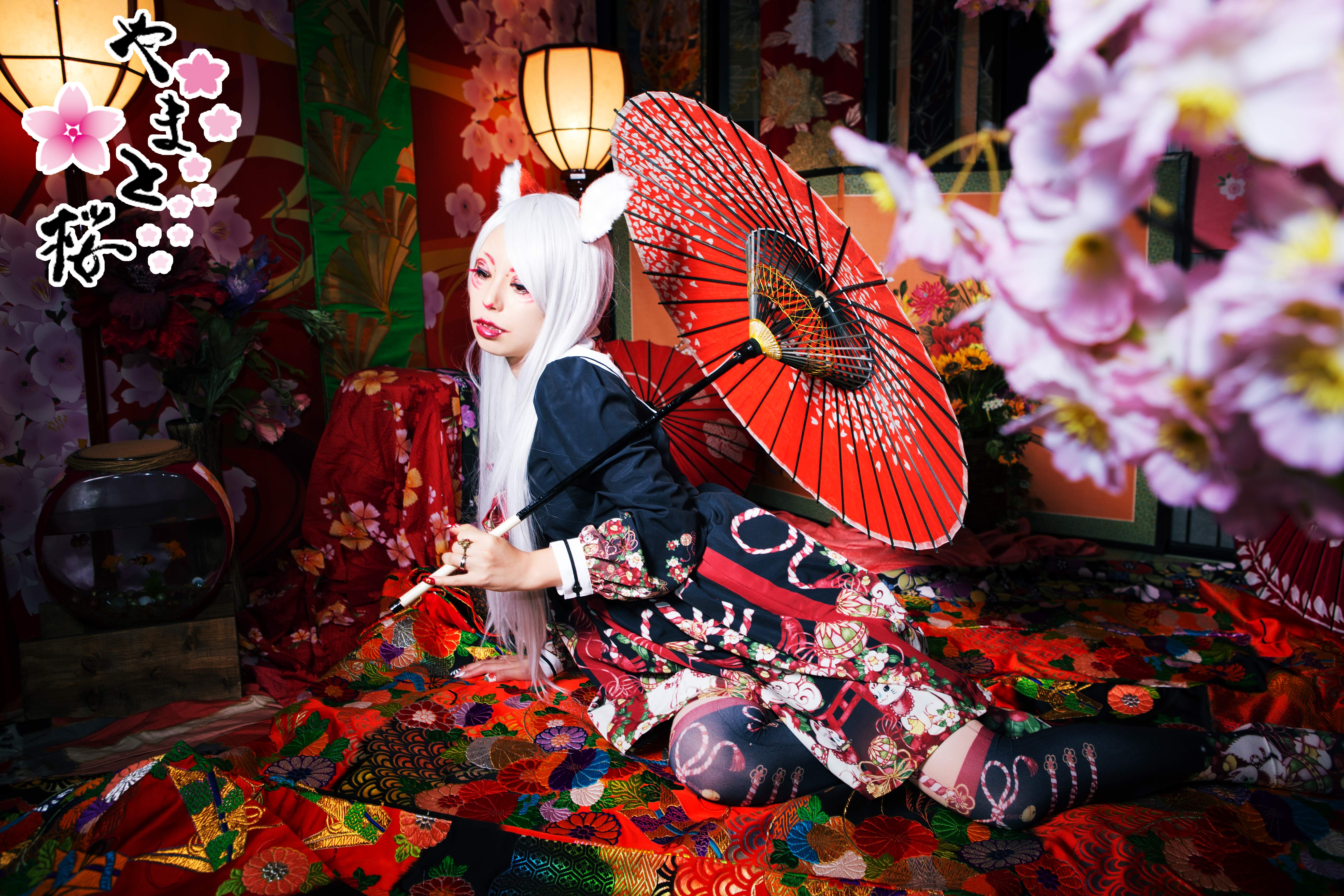 和傘を持ちながらくつろぐ白狐コスプレの女性